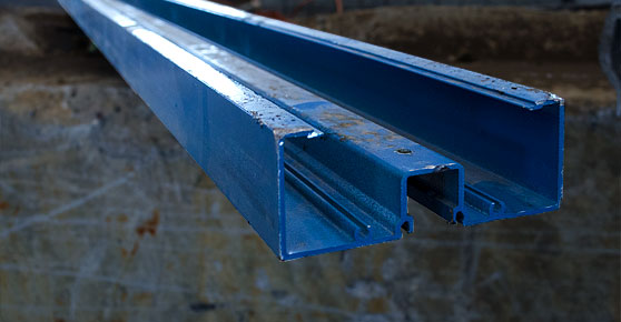 Painted Extruded Aluminum -  A blue steel beam hanging from a wall